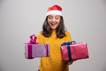 Young woman in Santa hat looking at her boxes