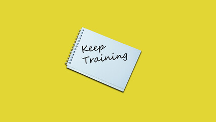 Keep Training Hand writing note on a notebook. lifestyle, advice, support motivational positive words are written on a solid background. Business, signs, symbols, concepts. Copy space.