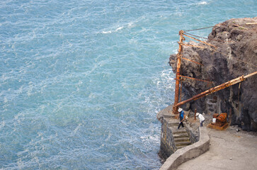 Couple of sport fishermen on an old pier. Tecina. San Sebastian de La Gomera. La Gomera. Canary Islands. Spain.