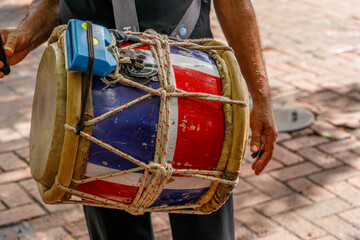 A musician plays merengue music. Tambor drum.