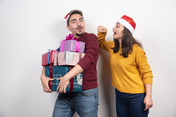 Man and woman carrying a lot of Christmas presents
