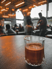 Dirty coffee in clear glass is placed on the table of a coffee shop where many people come to drink coffee each day. to add freshness.