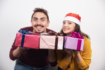 Young man with woman posing with Christmas presents