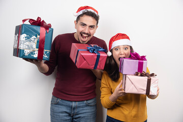Man and woman carrying a lot of Christmas presents