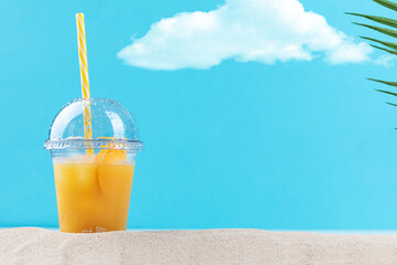 glass of orange juice on beach