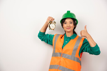 Female employee with thumb up and holding a clock
