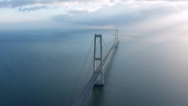 Aerial view on the car traffic at the Great Belt suspension bridge (&Oslash;stbroen) highway at sunset, Denmark