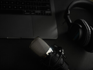 Laptop, studio microphone and studio headphones on a gray background. Low angle view. Modern...