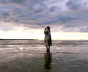 woman relaxing stay on beach  sea water wave  and watching dramatic cloudy sky on horizon nature landscape