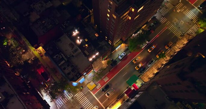 Yellow taxis and private transport running by the streets of metropolis at nighttime. Beautiful never sleeping New York from top view.