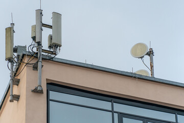 Fototapeta na wymiar New GSM antennas on the roof of a building for transmitting a 5g signal are dangerous to health. Radiation pollution of the environment through cell towers. The threat of extinction of the population