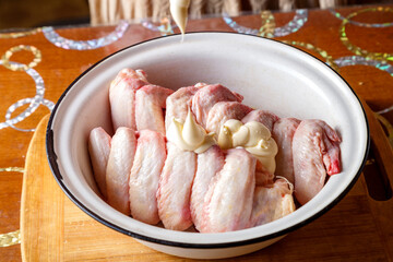 Dish with fresh raw wings on a wooden table. horizontal photo