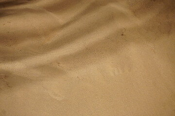 Rot-braune Sandfläche mit Wellenmuster