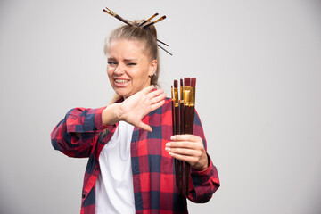 Blonde artist ignores her set of brushes