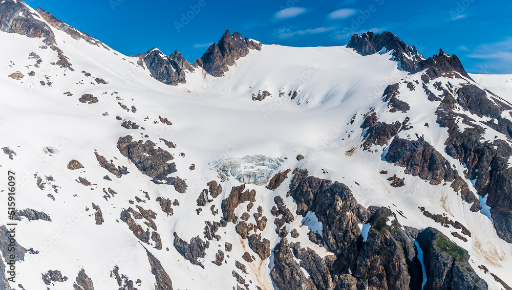 Wall mural an aerial view of the snowy mountain peaks above the denver glacier close to skagway, alaska in summ