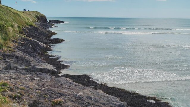 Rocky seashore on a sunny day. Blue ocean waters. Seaside landscape. Hand-held video 4k.