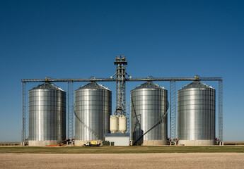 Four Grain Elevators Stand Tall Against Blue Sky © kellyvandellen