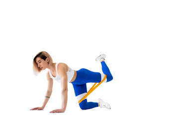 Sexy woman in sportswear using a resistance band in her exercise routine. Young woman performs fitness exercises on white background. Isolate