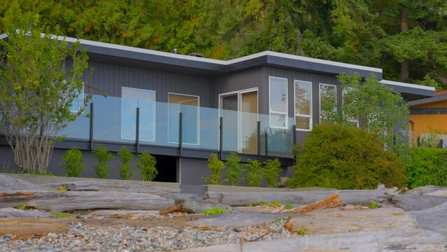 Establishing shot. Entrance of grey painted luxury house with stair steps, green trees and nice landscape in Vancouver, Canada, North America. Day time on June 2021. Zoom out. ProRes 422 HQ.