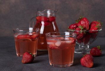 Strawberry Compote in two glasses and jug on brown background