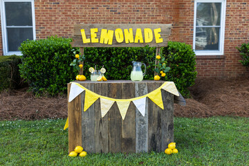 An empty lemonade stand ready for children to start selling lemonade on a hot summer day as their...