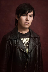 young man hispanic with leather jacket with look punk rocker