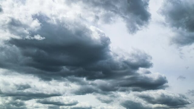 Dramatic cloudscape time lapse. Dark scene with white grey clouds