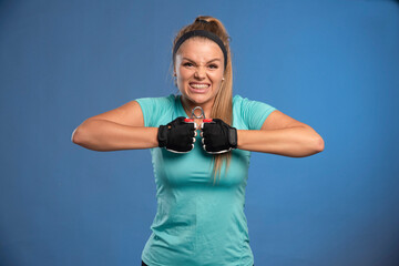 Young sportive woman with a hand stretching gum trying to solve it