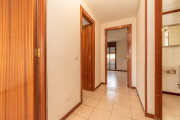 Corridor of a house with several doors and access to different rooms with light oak wooden floors
