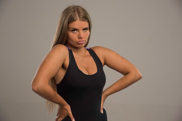 Fototapeta premium Female model in sport bra looks seductive with hands on the waist