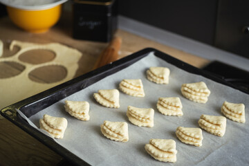 roll out puff pastry and make cookies on a dark background. Homemade cookies