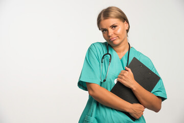 Blonde female doctor in blue uniform holding a receipt book on white background