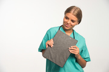 Blonde female doctor in blue uniform holding a receipt book and smiling