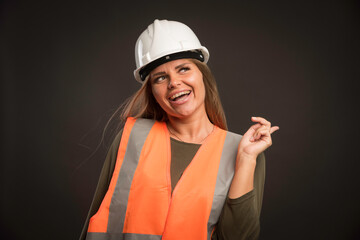 Female engineer wearing a white helmet and gear and looks motivated