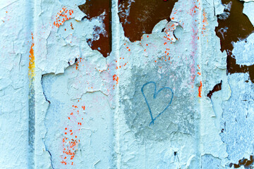 Texture. Many times painted surface with peeling paint. A heart is drawn.