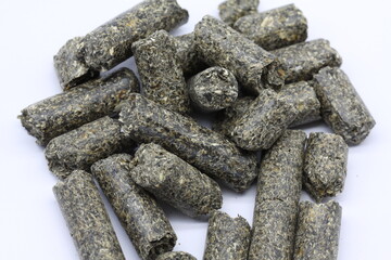 close-up photo of sunflower meal pellets with white background.