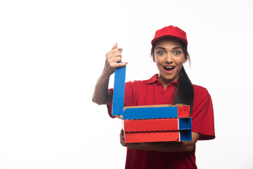 Delivery female employee in red cap holding a cardboards of pizza