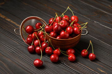 Sweet fresh cherry on a dark wooden background.