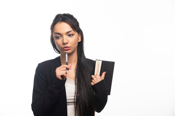 Businesswoman holding a notebook on white background