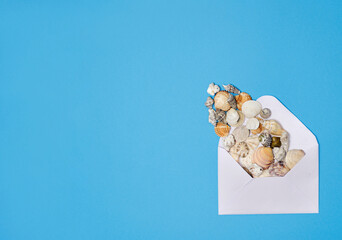 Summer scene with envelope and sea shells. Flat lay. Creative copy space.