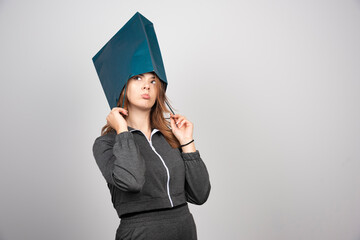 A young woman putting a shopping bag over her head