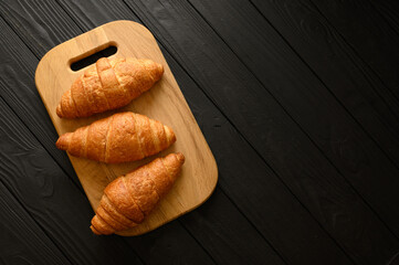 Fresh croissants on a wooden background.