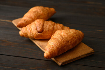Fresh croissants on a wooden background.