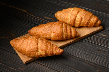 Fresh croissants on a wooden background.