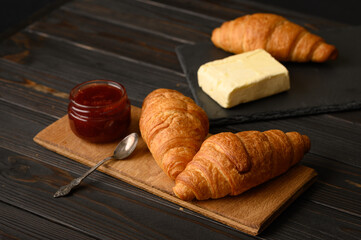 Tasty and delicious croissants with jam on a wooden table