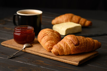 Tasty and delicious croissants with jam on a wooden table
