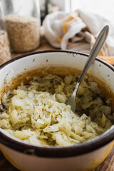 fresh young cabbage to dinner in a metal pot in the kitchen (selective focus, blurred background)