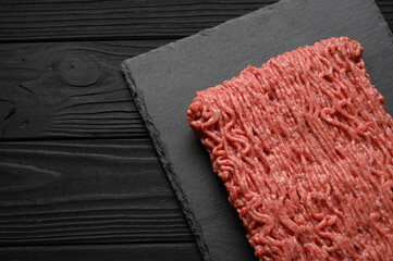 Raw mince beef, ground meat. Black background. Top view. Copy space