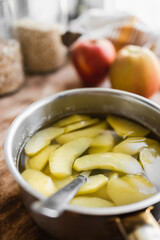 compote of fresh apples in a metal pot in the kitchen (selective focus, blurred background)