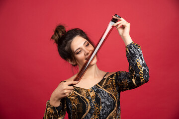 Brunette girl checks her photo history on polaroid film and looks satisfied
